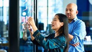 woman and man looking at post-it notes