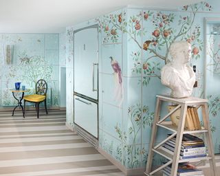 A kitchen with turquoise tiled walls hand-painted with muralistic motifs of birds, animals, fruit trees and flowers