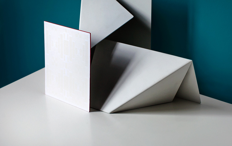A faintly de-bossed Art Deco pattern in matte white foil ornamented this white card with red edges