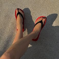 An image of @annabelrosendahl wearing red-and-black flip-flops. 