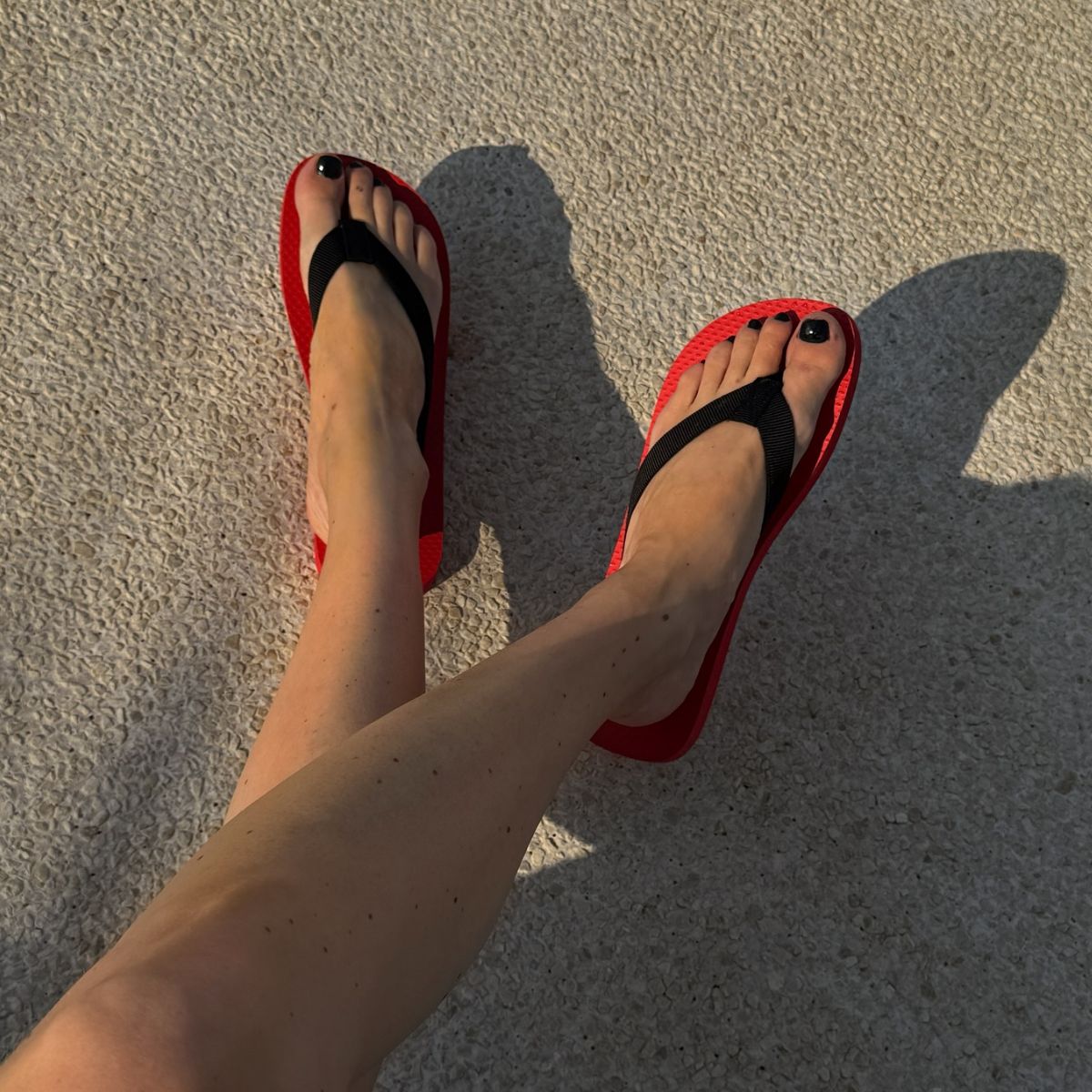 An image of @annabelrosendahl  wearing red-and-black flip-flops. 