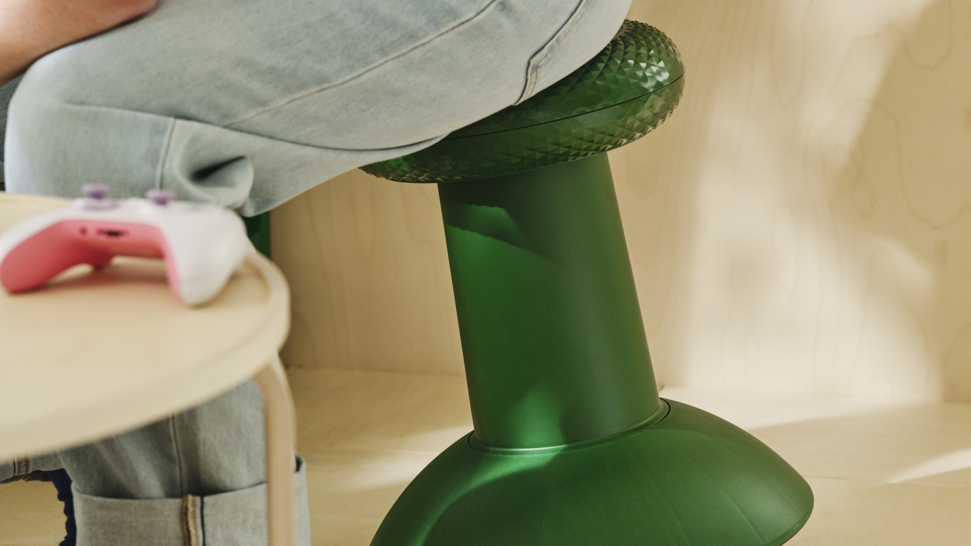 Person leaning forwards on Ikea / Xbox thumbstick stool as the seat tilts with them