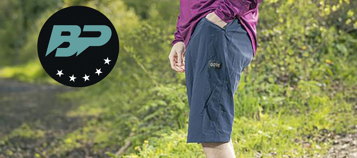 Man wearing Gore Wear Fernflow Shorts with grassy backdrop