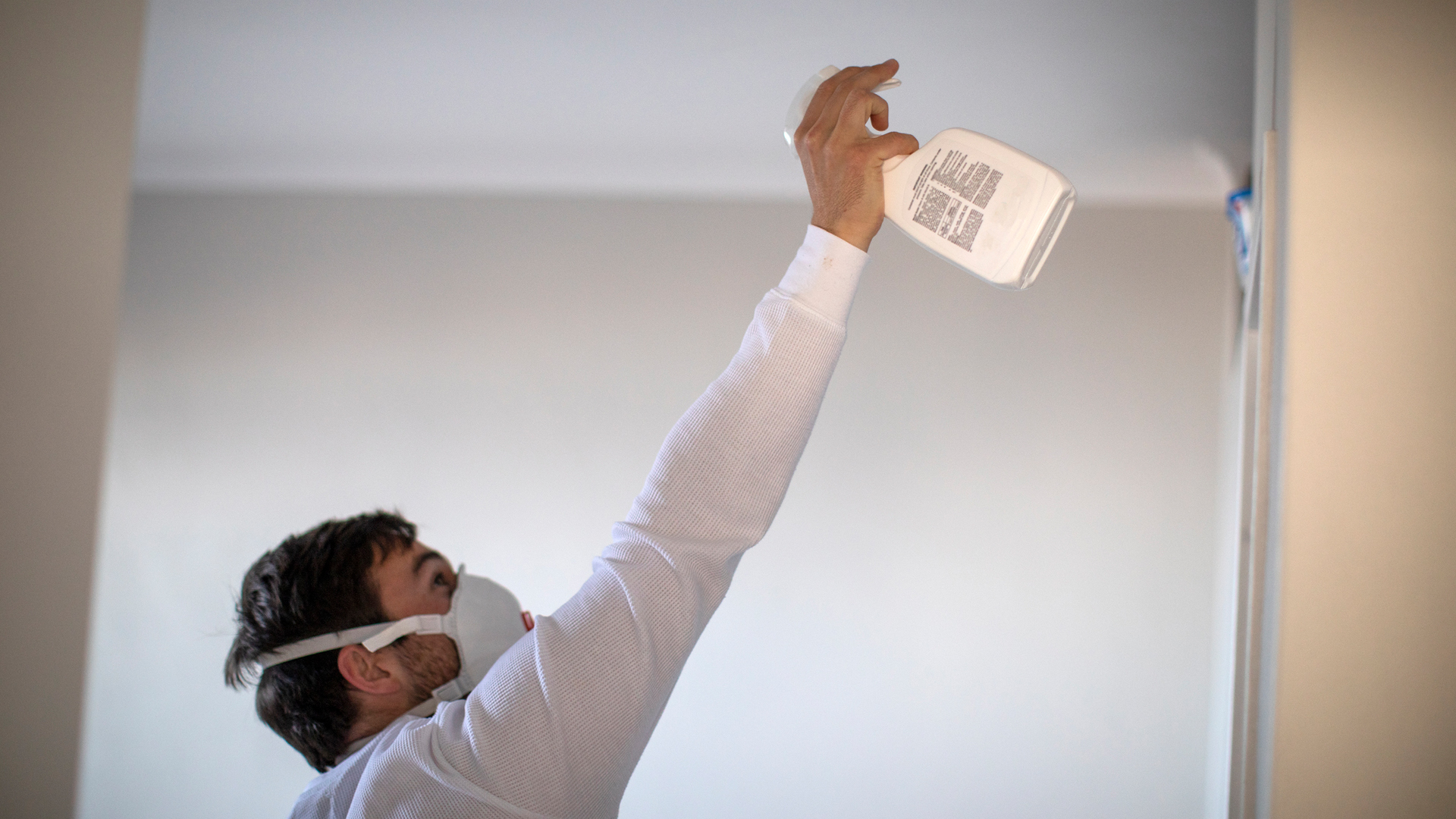 man spraying mold in his house