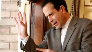 Tony Shalhoub as Monk looking through a window in Monk