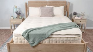 Naturepedic Concerto Pillow Top mattress placed on a bedframe in a white bedroom