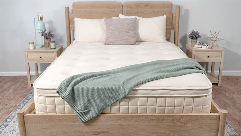 Naturepedic Concerto Pillow Top mattress placed on a bedframe in a white bedroom