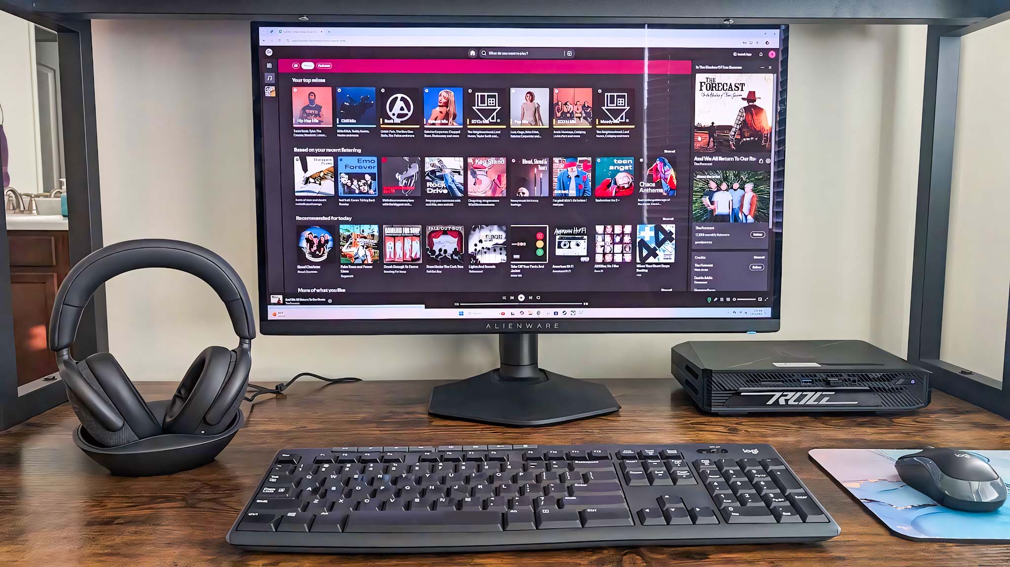 Dell Premiere Wireless ANC WL7024 headset on a desk next to a monitor, keyboard, and mouse.