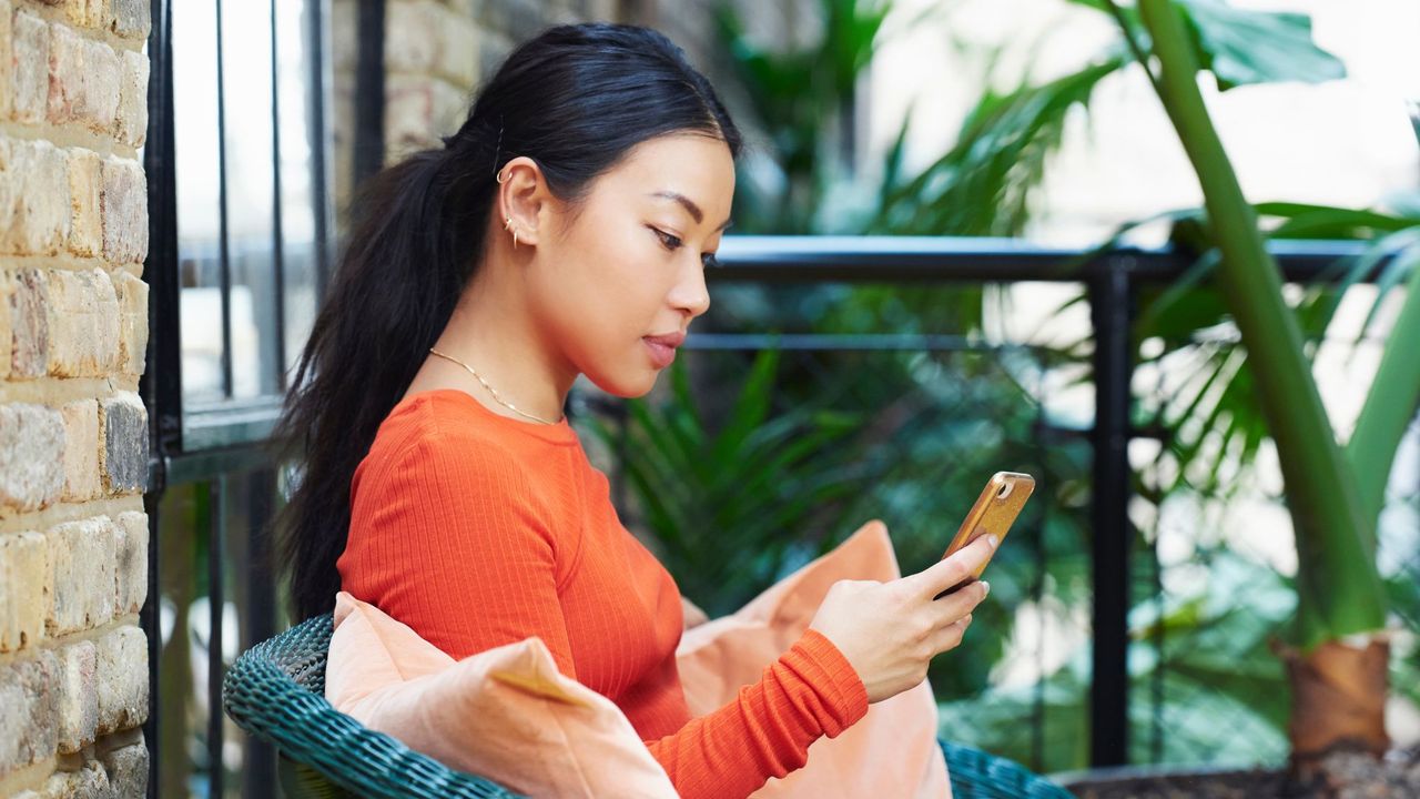 A woman using one of the best mental health apps on her mobile phone