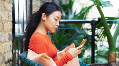 A woman using one of the best mental health apps on her mobile phone