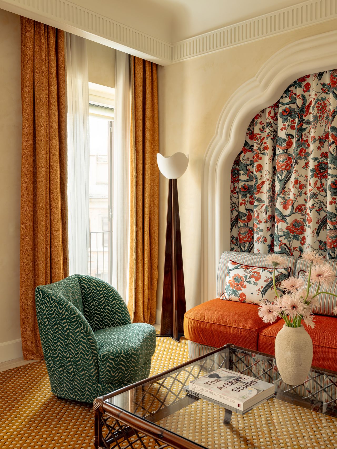 A maximalist hotel in Rome features vibrantly decorated, layered interiors, including plush upholstery, rattan accents, sculptural lighting, and artefacts.