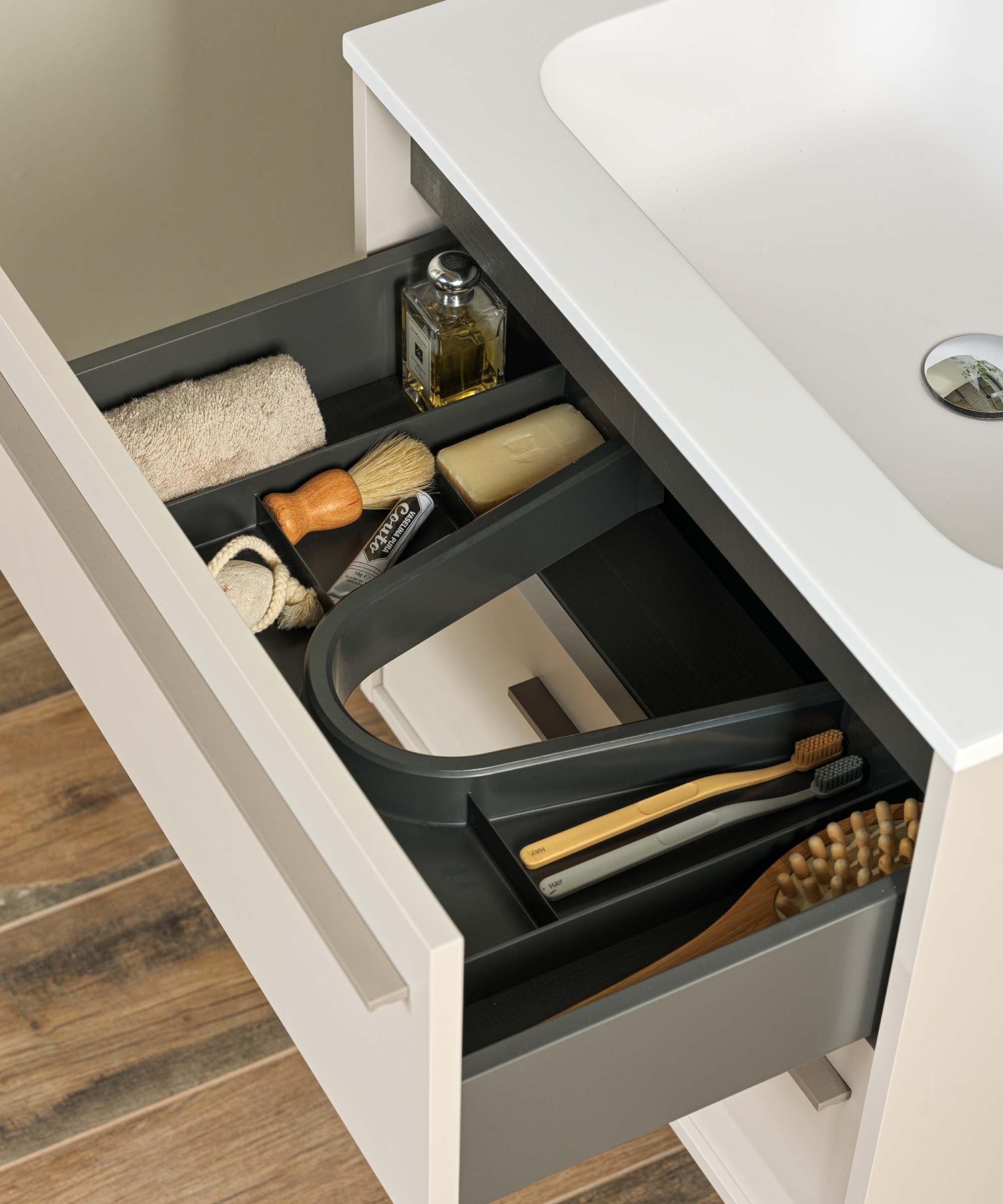 open drawer in vanity unit showing storage tray and items inside