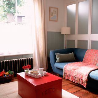 living room with blue sofa and red table