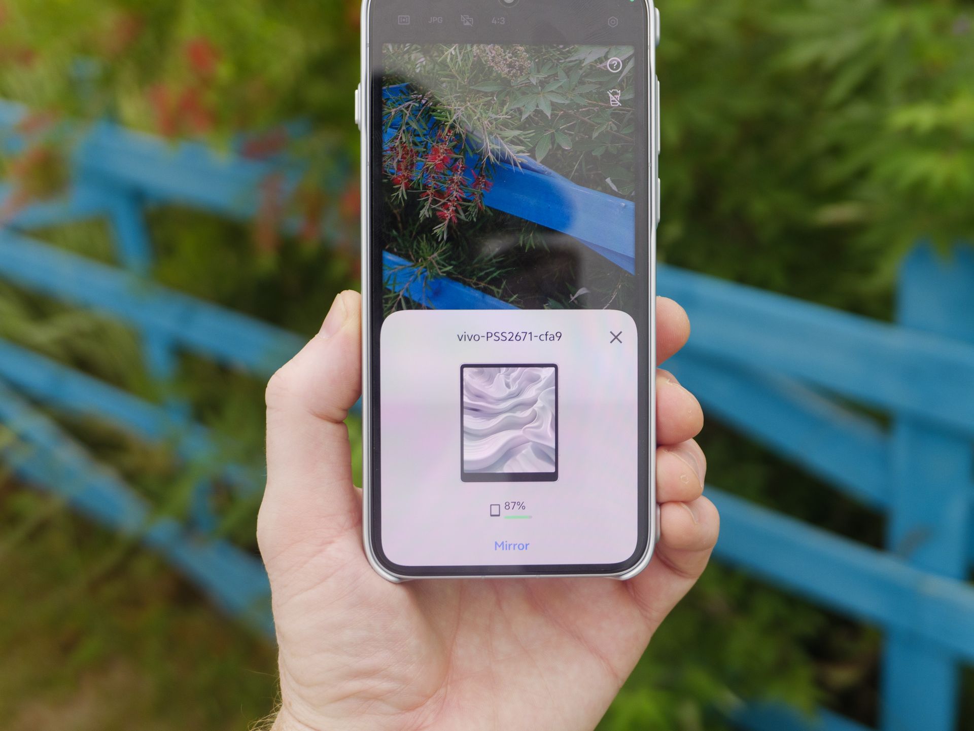 The Vivo X500 Pro Max phone in user's hand, in its dedicated case for magnetic accessories, with Vivo's selfie screen attached and the initiating option is on the phone's screen