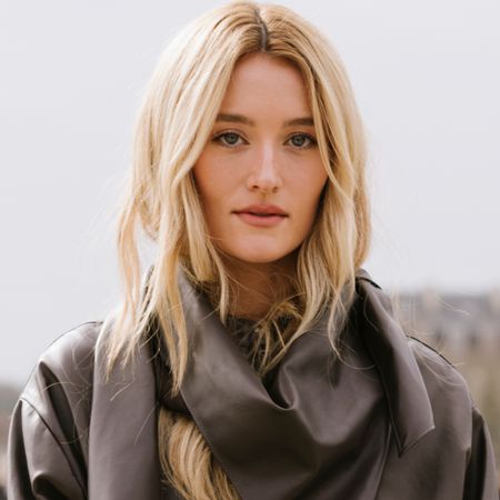 Sarah Pidgeon attended the Loewe Fall 2026 show in a brown leather version of the scarf coat trend