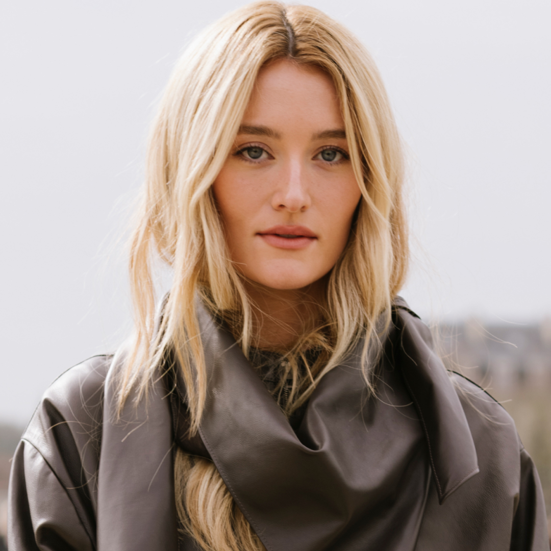 Sarah Pidgeon attended the Loewe Fall 2026 show in a brown leather version of the scarf coat trend