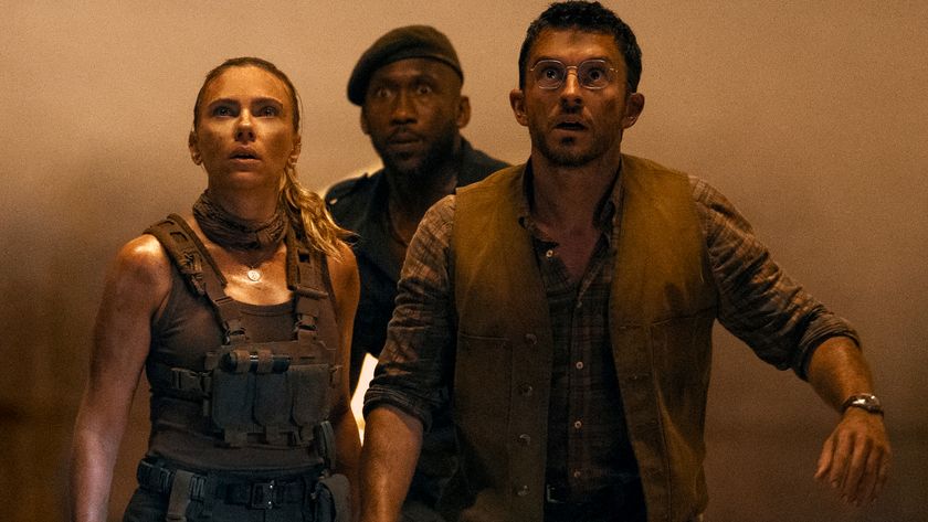 Scarlett Johansson, Mahershala Ali, and Jonathan Bailey look ahead in horror in a dim tunnel in Jurassic World Rebirth.
