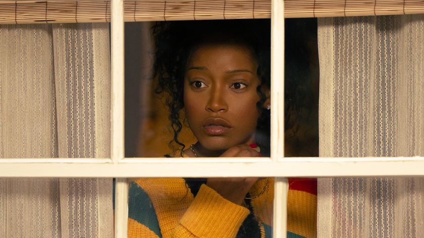 Keke Palmer looking through window and curtains in Peacock&#039;s The Burbs series