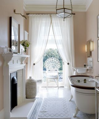 sheer window curtains in a vintage traditional bathroom with claw foot bathtub