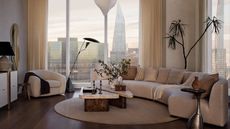 modern apartment living room with city skyline views, a curved cream couch, a cream armchair, marble nesting coffee table, round rug, and plant in corner of the room