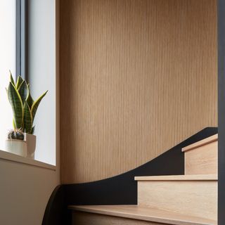 A curved staircase with vertical wood slat panelling on the wall