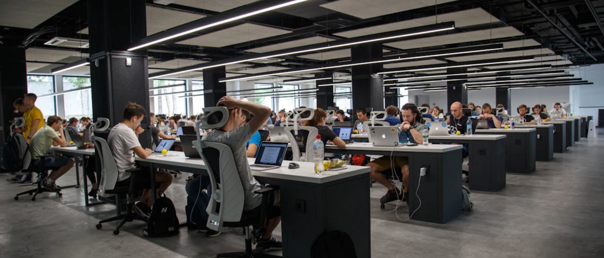 Office with many desks and workers at computers