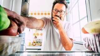 intuitive-eating-man-reaching-into-fridge