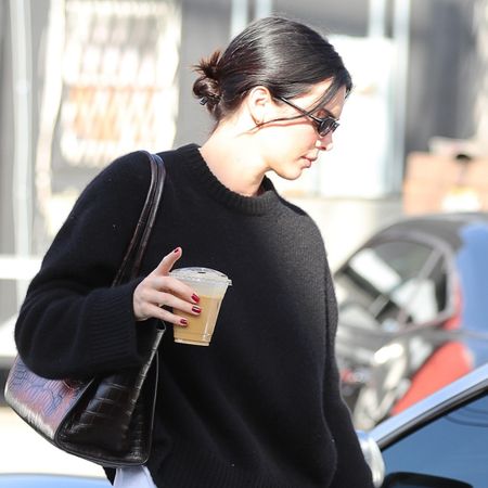 Kendall Jenner in Los Angeles wearing a black sweater, loose black pants, red The Row ballet flats, and a croc shoulder bag 