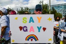Protester holding a sign that reads "Say Gay"