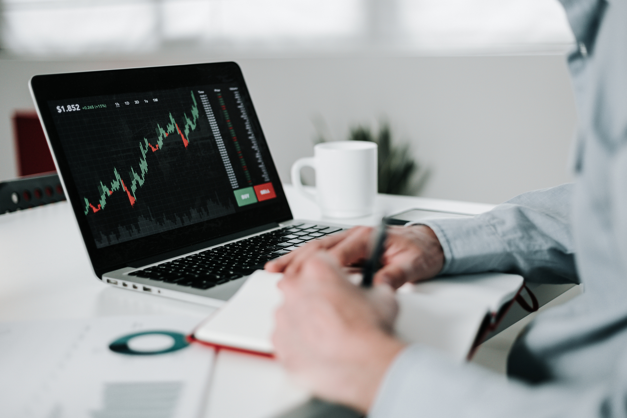 Person looking at stock market data on laptop