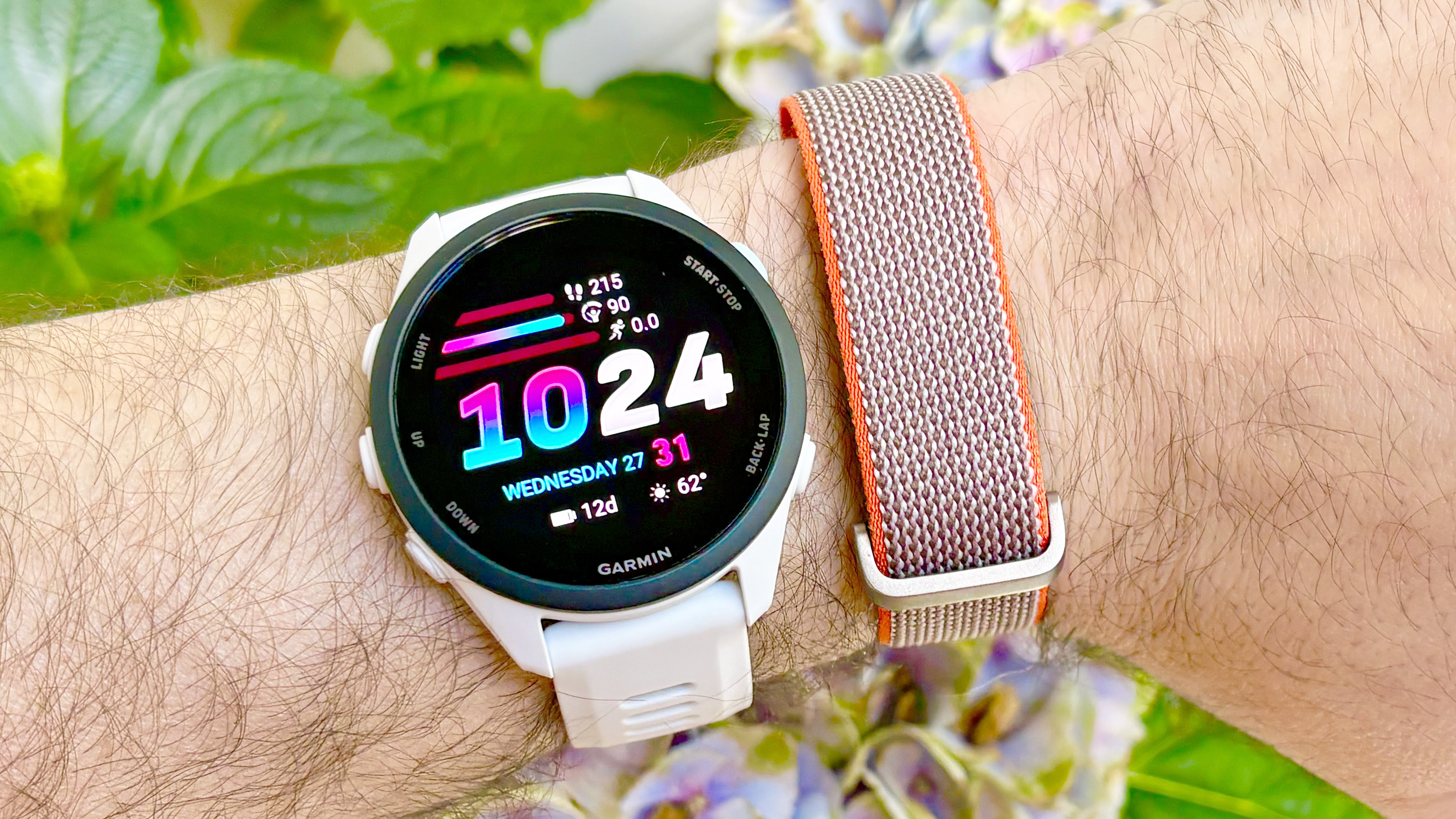 Close-up of the Garmin Forerunner 70 next to the Fitbit Air fitness tracker on the same wrist