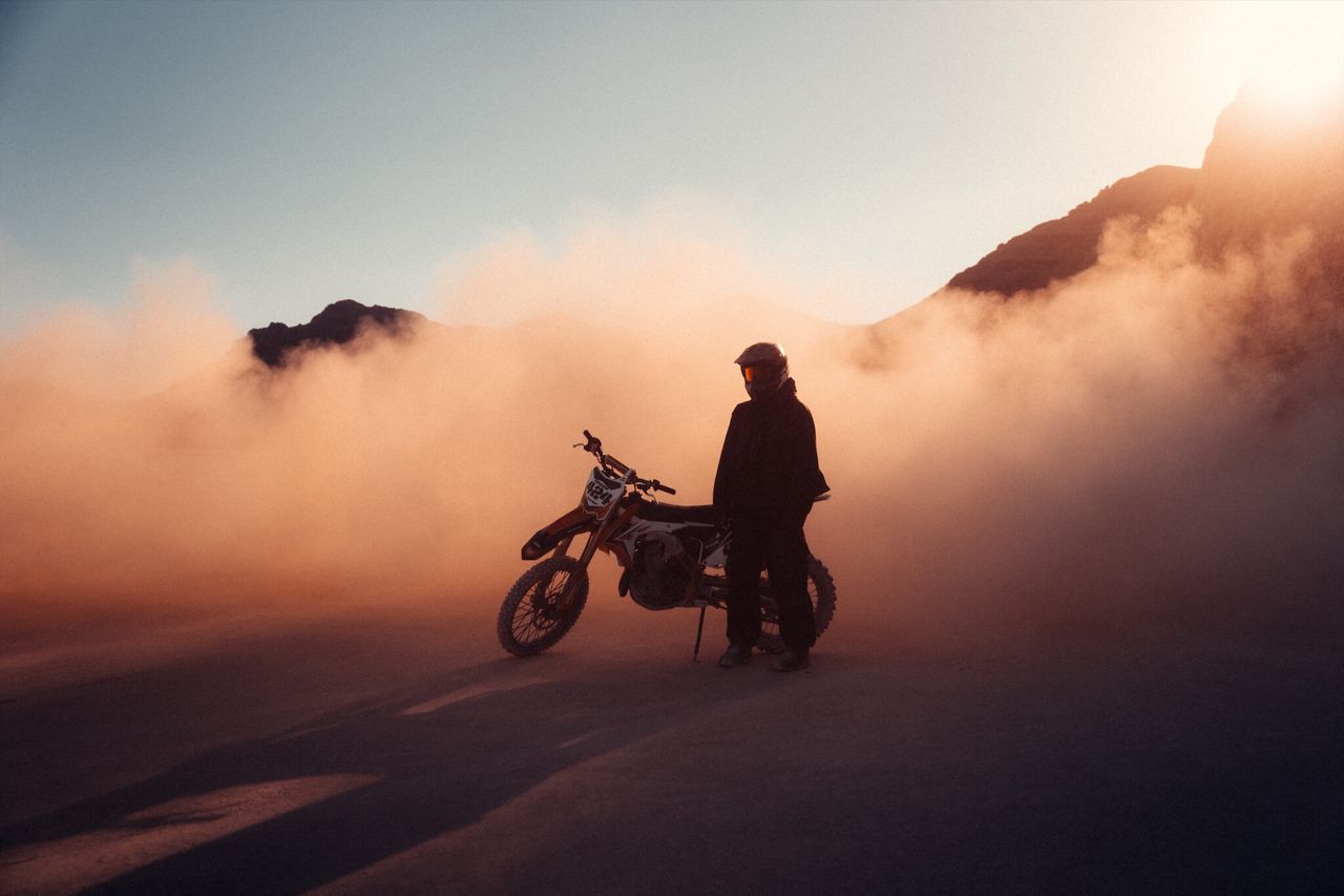 Dirt biker in dusty scene.