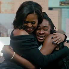 Michelle Obama embracing a young girl in her documentary, Becoming.