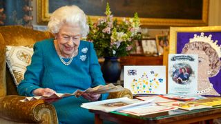 Queen Elizabeth II during her Platinum Jubilee reading cards from fans