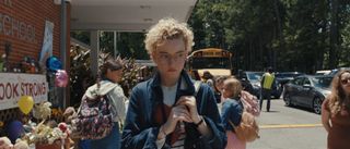 Julia Garner as Justine walking outside a school in Weapons