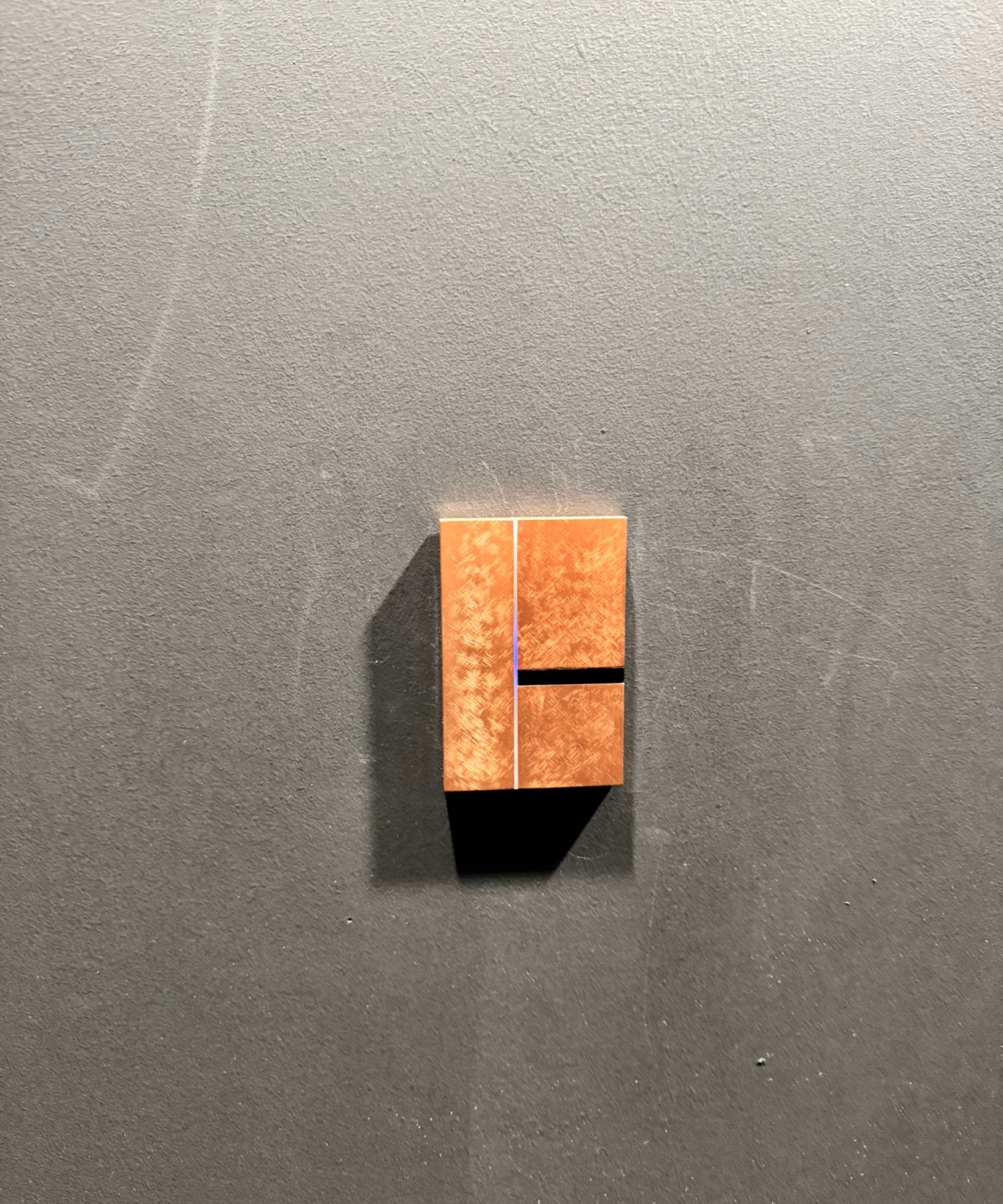 Basalte light switch on gray wall.