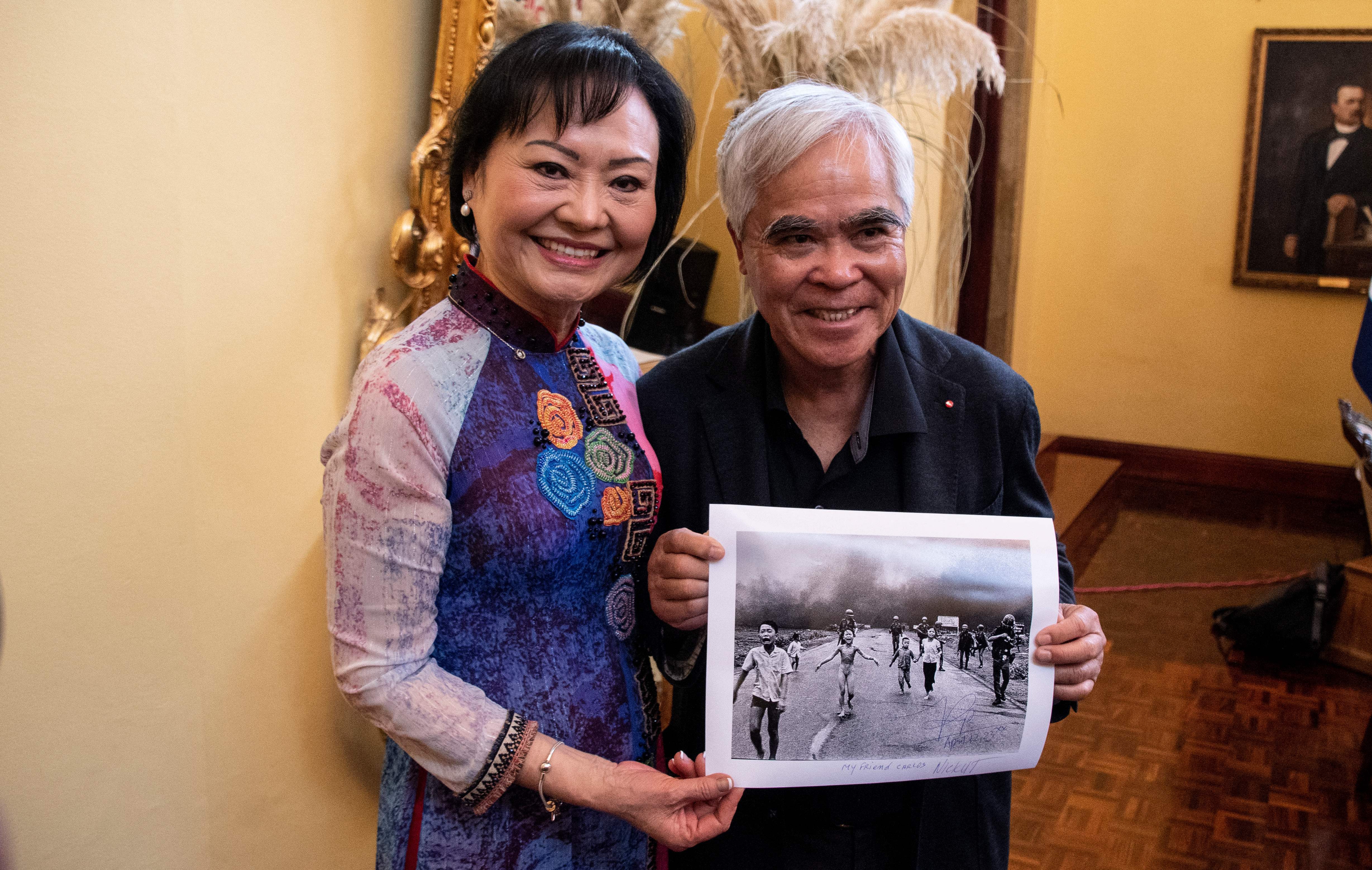Vietnam War survivor Kim Phuc Phan Thi (L), also known as the "Napalm Girl," poses with photojournalist Nick Ut holding his 1972 Pulitzer Prize and World Press Photo award-winning photograph during the presentation of the Spanish edition of her book at the Ministry of Foreign Affairs and Worship in San José on April 12, 2023