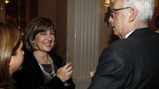 Christiane Amanpour smiles while talking with two other people.