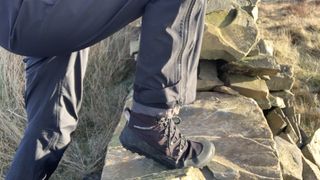 A hiker's legs as they climb over a stone stile