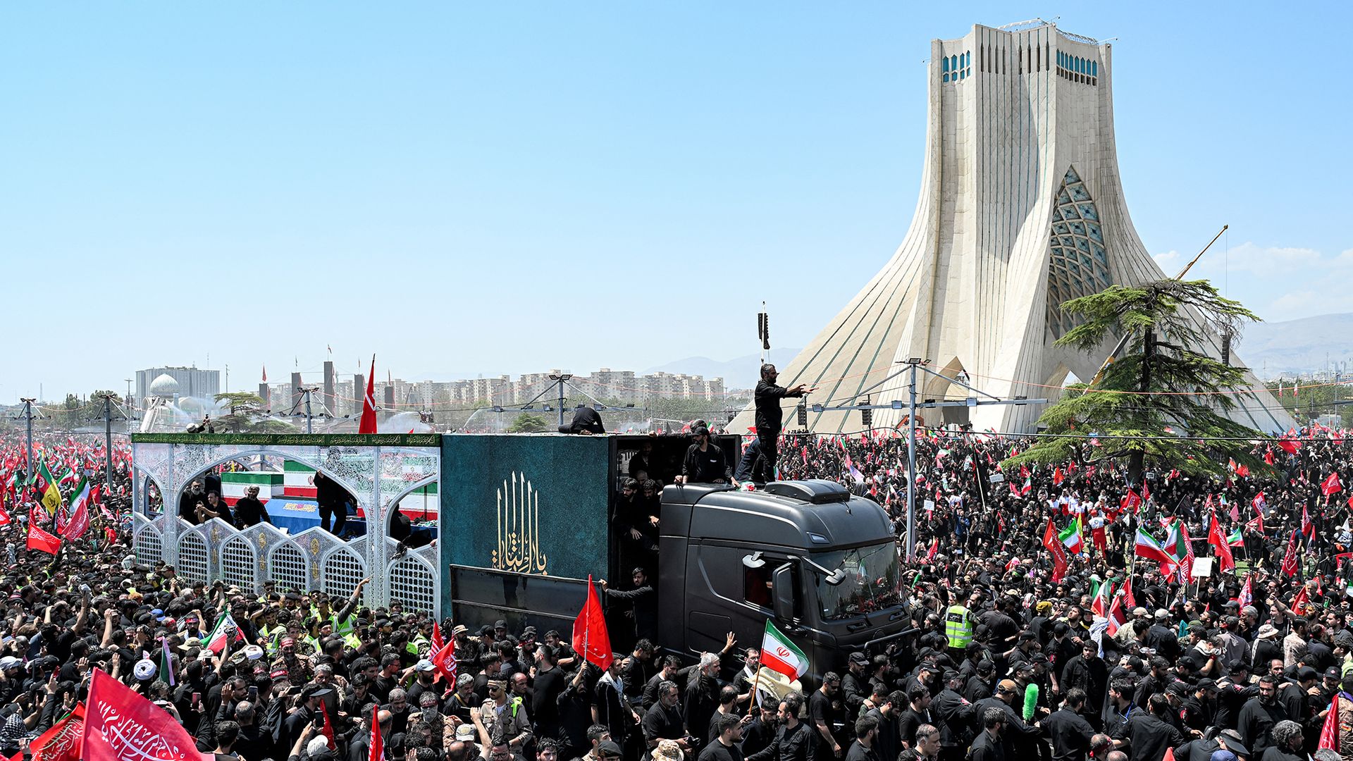 
                                Mourners gather around the vehicle transporting the casket of Iran's slain supreme leader Ali Khamenei during the funeral procession at Azadi Tower in Tehran, Iran
                            
