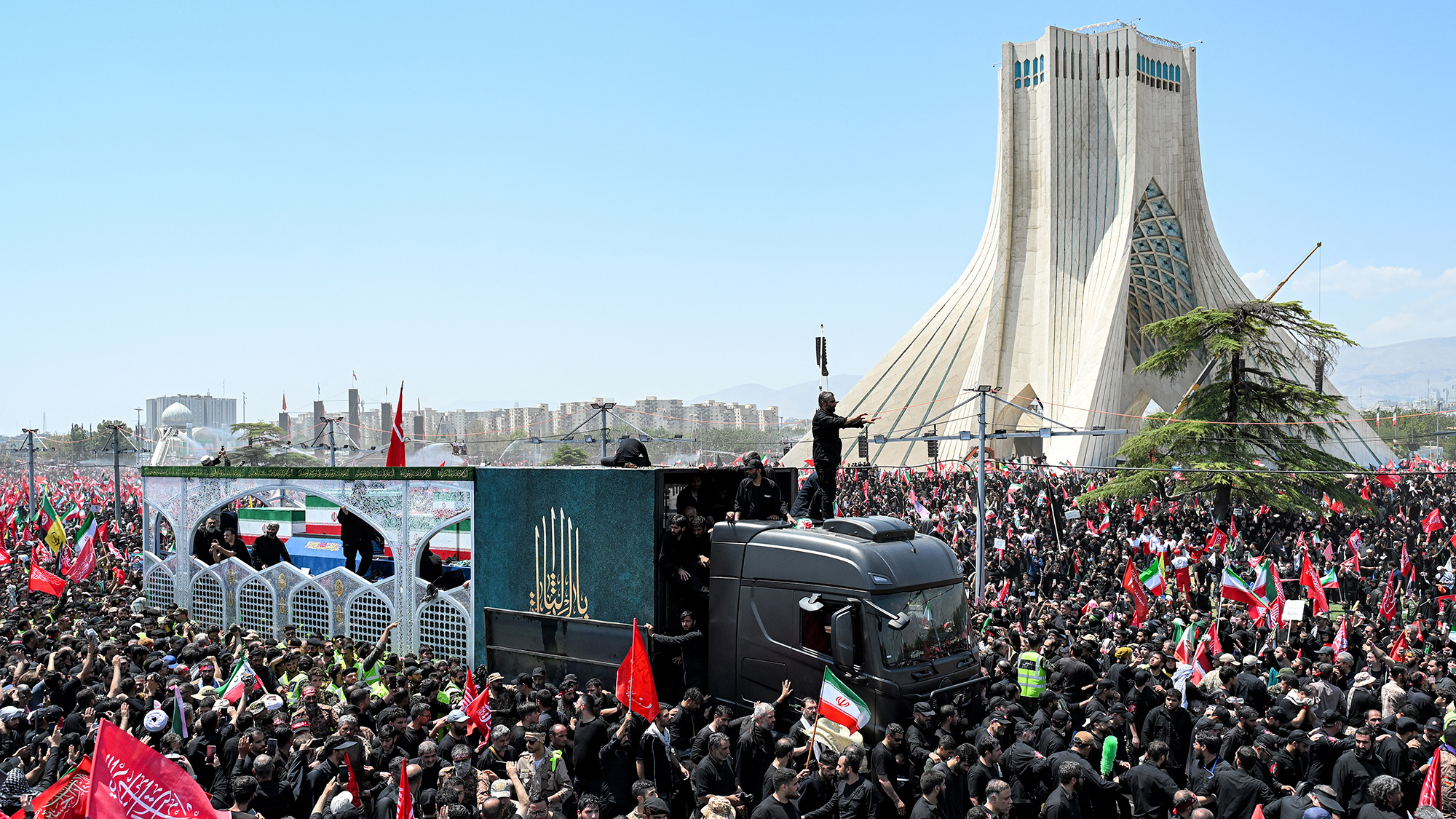 Mourners gather around the vehicle transporting the casket of Iran's slain supreme leader Ali Khamenei during the funeral procession at Azadi Tower in Tehran, Iran
