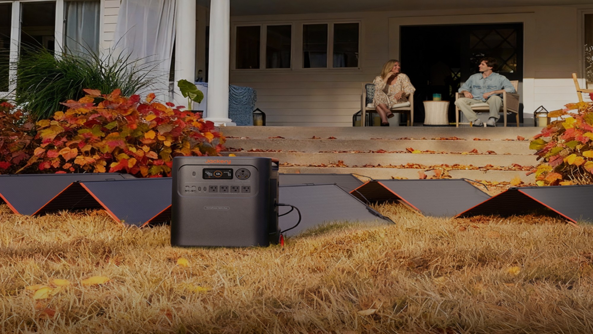 Jackery device on a field with couple sitting on porch
