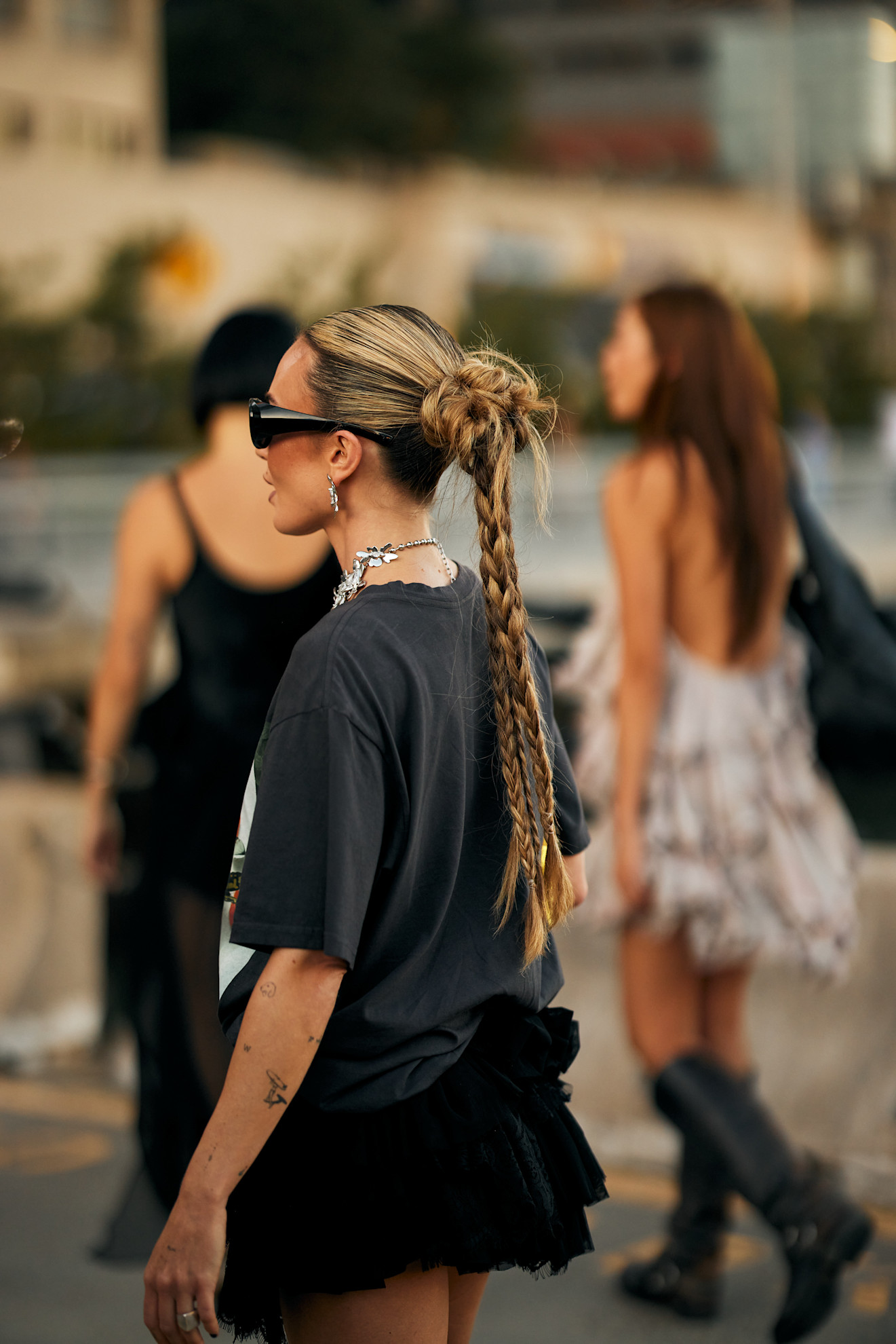 a woman wearing a black t-shirt with long blonde triple strand braids and sunglasses