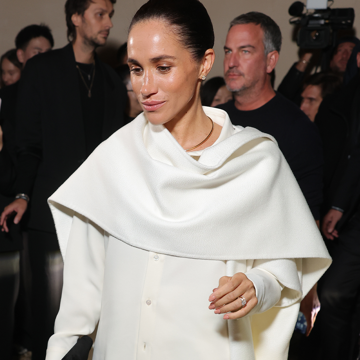 Photo of Meghan Markle wearing white scarf top.