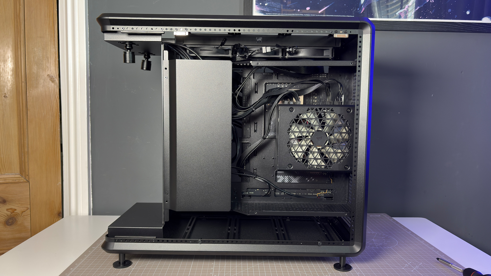 The CoolerMaster MasterFrame 360 Panoramic PC case with various components installed on a desk.