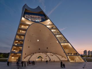 sun tower by open architecture, a curved, sloping, concrete tower, half open to the elements and looking out towards the sea