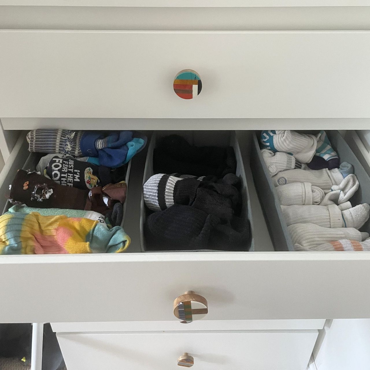 Socks in drawer organisers in a white chest of drawers