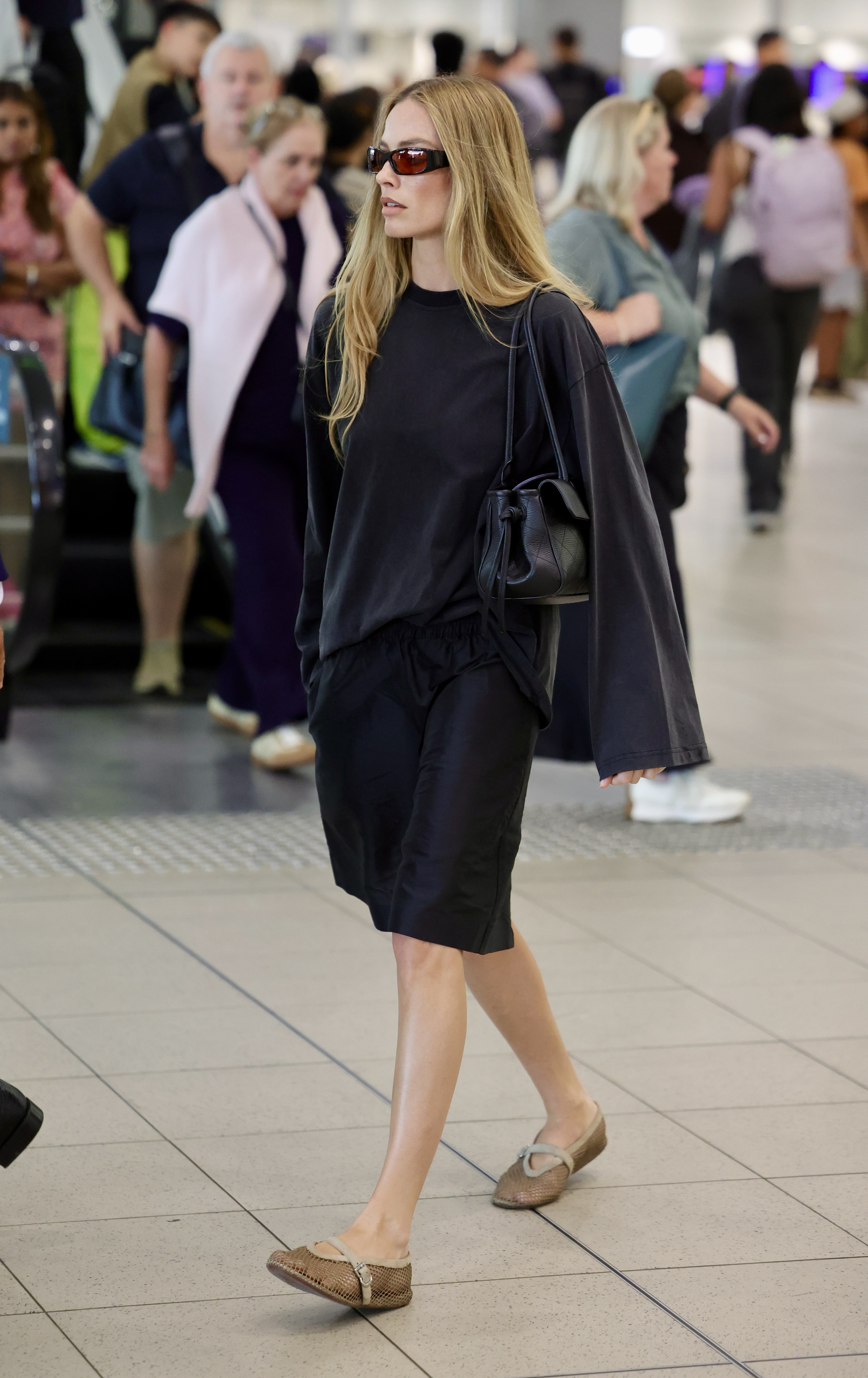 Margot Robbie at the Australia airport in a Fall 2026 elongated Bermuda shorts trend