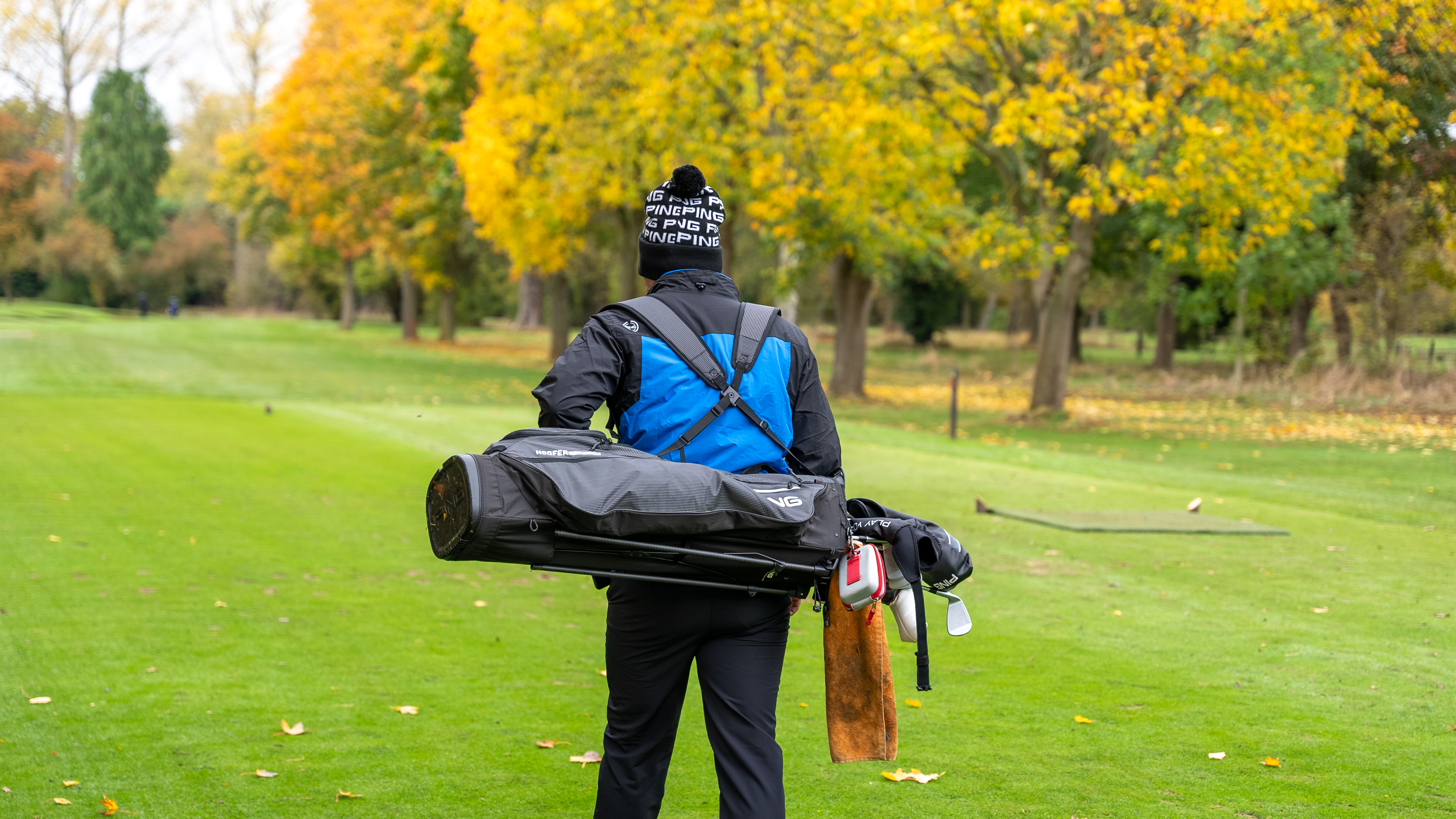 A golfer walking to the tee box