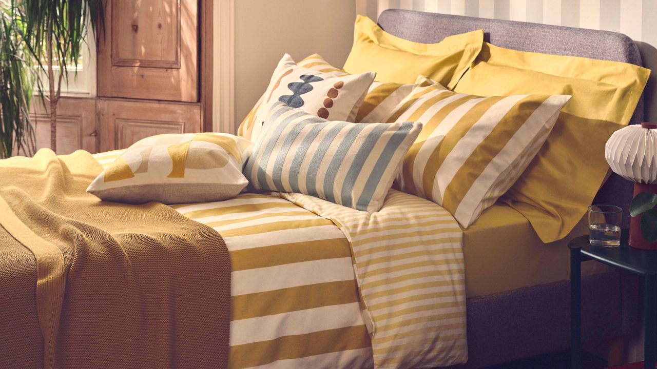 A bed with a striped yellow bed linen